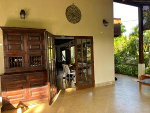 a room with a wooden door and a dining room at Casa Chalé dos Pássaros Guarajuba in Camacari