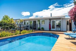 a swimming pool in front of a house at Studio Twenty5, Unique Poolside Retreat Near Nelson in Richmond