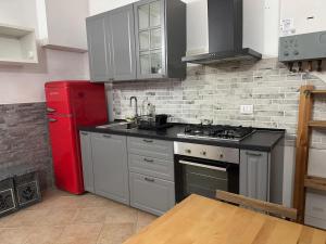 a kitchen with a stove and a red refrigerator at Appartamento A&S-Centro Argenta in Argenta