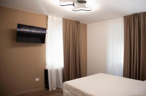 a bedroom with a bed and a flat screen tv at Paponena Holidays in Riva del Garda