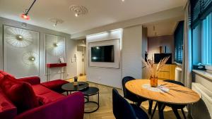 a living room with a red couch and a table at Apartament Acaia Old Town in Gdańsk