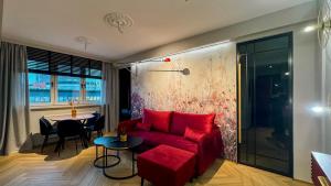 a living room with a red couch and a table at Apartament Acaia Old Town in Gdańsk