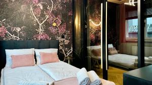 a bedroom with a bed with pink pillows at Apartament Acaia Old Town in Gdańsk