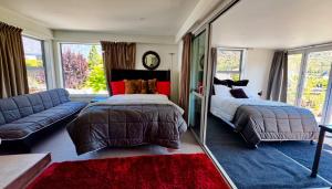 a bedroom with a bed and a couch and a mirror at Airport Guesthouse in Queenstown