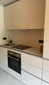 a kitchen with white cabinets and a black oven at Refugium in Schwaigen +2 photos
