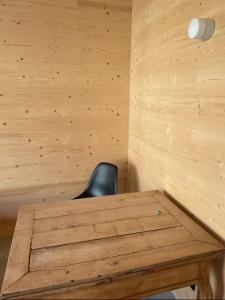 a wooden table in a room with a black chair at Refugium in Schwaigen