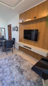 un salon avec une télévision à écran plat sur un mur dans l'établissement Apartamento de descanso com a brisa do Mar!, à Lauro de Freitas