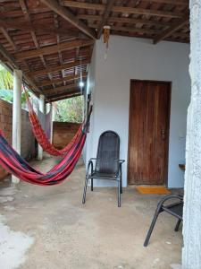 a hammock in a room with a chair and a door at Casa Recanto da Paz in Sao Jorge