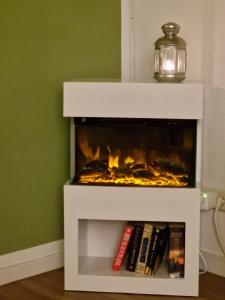 een witte open haard in een kamer met boeken bij Galeriewohnung Ritter Ramm mit kostenlosem Parkplatz und Kamin, Bahnhof fußläufig in Goslar