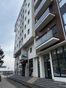 a tall white building with windows on a street at Angelina Art in Trnava