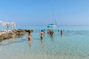 a group of people in the water at the beach at Afitos Guest House in Afitos