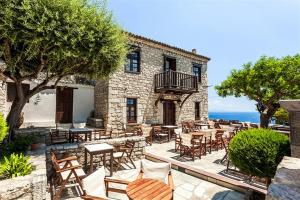 an outdoor patio with tables and chairs and the ocean at Afitos Guest House in Afitos +40 photos