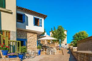 a building with tables and chairs and an umbrella at Afitos Guest House in Afitos