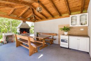 a large patio with a table and a fireplace at Old Stone Villa Katarina in Nedeščina