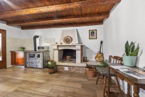 a living room with a fireplace and a table at Old Stone Villa Katarina in Nedeščina