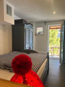 ein Schlafzimmer mit einem Bett, auf dem ein roter Hut liegt in der Unterkunft Armis Tiny House in Valzeina