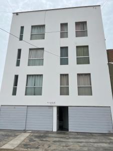 a white building with two garage doors at DEPARTAMENTO SAN BARTOLO-2dormitorios in Lima