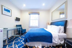 a bedroom with a bed and a desk and a window at Hyde Park Rooms & Apartments in London