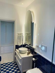 a bathroom with a white sink and a mirror at Casa Torre a Sorrento con parcheggio gratuito in Sorrento