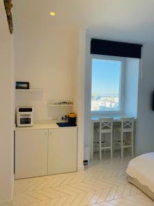 a room with a kitchen and a bed and a window at Casa Torre a Sorrento con parcheggio gratuito in Sorrento +15 photos