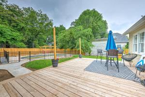 a wooden deck with a table and a blue umbrella at Decca's Guesthouse in Siloam Springs