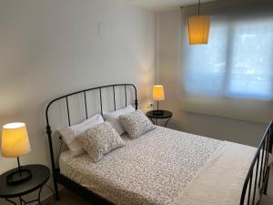 a bedroom with a bed with pillows and two lamps at Apartamento Port Dénia in Denia +26 photos