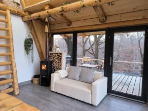 a living room with a white couch and a fireplace at Cabana A in Şurdeşti