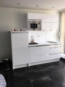Biała kuchnia ze zlewem i kuchenką mikrofalową w obiekcie Résidence Héliopolis Bâtiment K - Studio 2 pers. Héliopolis K MAE-4604 w Cap d'Agde