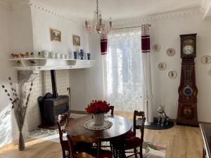 a dining room with a table and a clock at La Maison Marguerite in Herrère