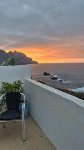 a chair sitting on a wall next to the ocean at Casa lucas in Almáciga