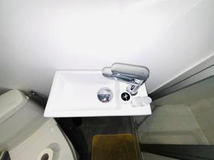 ein weißes Waschbecken im Bad mit WC in der Unterkunft Appartement porte de Saint Ouen in Paris