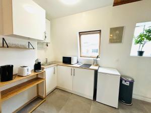 eine kleine Küche mit weißen Schränken und einem Fenster in der Unterkunft Appartement porte de Saint Ouen in Paris + 7 Fotos