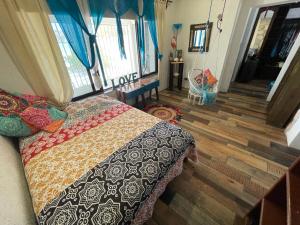 a bedroom with a bed with a quilt on it at SandyToes La Casita del Mexicano in Celestún