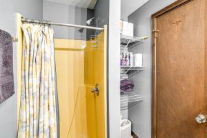 a shower with a yellow shower curtain in a bathroom at Cortland Townhome - Walk to Greek Peak Mtn Resort! in Cortland +25 photos