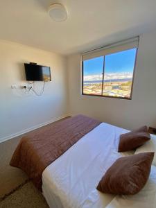 a bedroom with a large bed with a large window at Departamentos Caldera Suites in Caldera