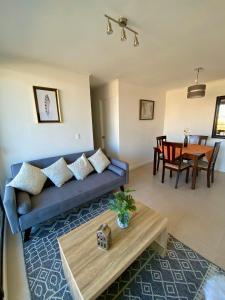 a living room with a blue couch and a table at Departamentos Caldera Suites in Caldera +18 photos