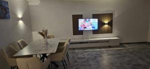ein Esszimmer mit einem Tisch und einem Fernseher an der Wand in der Unterkunft Whole Apartment Marechal near zurich airport free Parking Wifi in Hohentengen