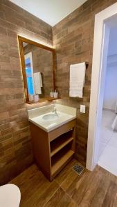un bagno con lavandino e specchio di Nô Centro Suítes 3 - Apto moderno com cozinha compartilhada a Florianópolis Altre 13 foto