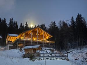a large wooden house in the snow at night at Sonnberg Chalet - Entspannung pur im Luxus Chalet mit Whirlpool-Sauna in Lachtal