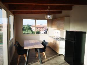 een keuken met een tafel, stoelen en een koelkast bij Appartamento a due passi dal mare in Condoianni