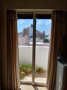 ein Fenster mit Blick auf einen Balkon mit Pflanzen in der Unterkunft Depto Córdoba centro 4 ambientes in Cordoba
