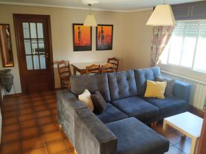 ein Wohnzimmer mit einem blauen Sofa und einem Tisch in der Unterkunft Doniños Paraíso in Ferrol