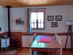 a dining room with a wooden table and chairs at Casa da Jaqueira 03 quartos em Santa Teresa ES in Santa Teresa