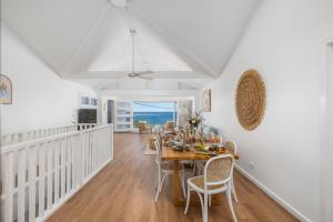 une salle à manger avec une table et des chaises et l'océan dans l'établissement Waves at Boat Harbour, 65 Kingsley Dr - stunning house, fantastic waterviews and dog friendly, à Boat Harbour