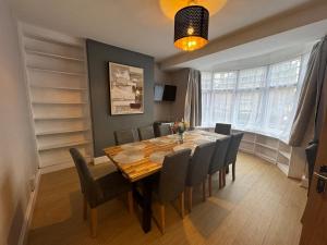 a dining room with a wooden table and chairs at Very Large Central Property in Dudley