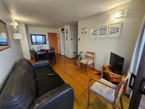 a living room with a leather couch and a television at Temporary Rent Viña del Mar in Viña del Mar