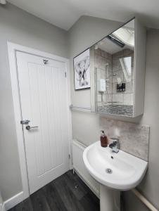 a white bathroom with a sink and a mirror at Modern Spacious Apartment Steps from City Centre in Norwich