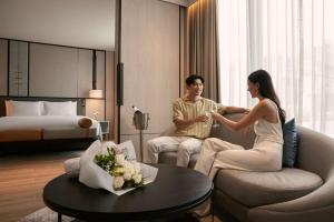 a man and a woman sitting in a hotel room at dusitD2 Samyan Bangkok in Bangkok