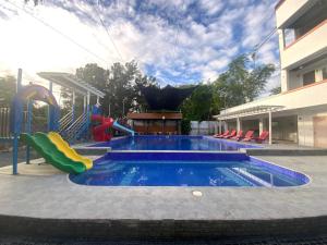 a swimming pool with a slide and a playground at EA Apartelle - Metro Vigan in Vigan