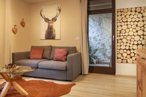 a living room with a couch and a deer on the wall at HIRSCH Stadt Apartment 2 - Terrasse mit Flussblick - Parkplatz in Bad Harzburg